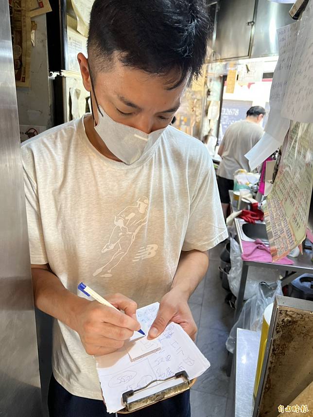 楊皓崴認真記錄客人的點餐需求。(記者李紹綾攝)