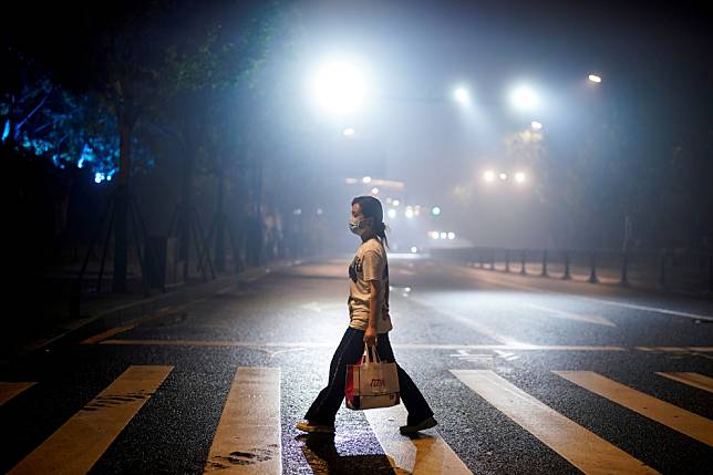 圖為一名女性走在夜晚的武漢大街上。幾周前，在中國網路上掀起一陣波濤的《武漢日記》正式在亞馬遜上開賣，讓人們更加好奇究竟這本書寫出了什麼樣的秘密，何以引來網路上排山倒海的批評？ 路透社/達志影像