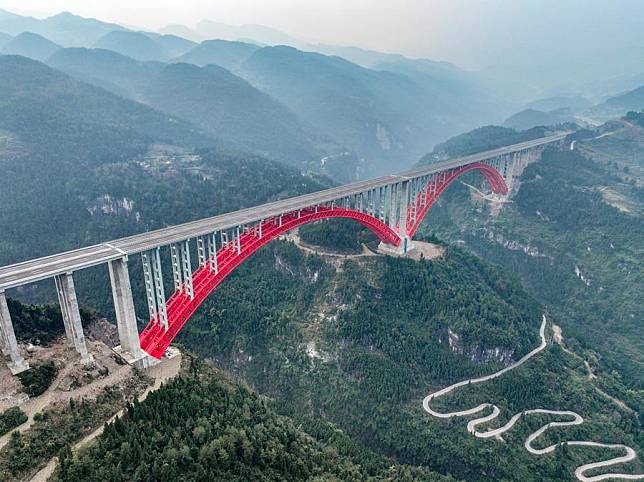 This aerial drone photo taken on Jan. 1, 2025 shows the Shuangbu super major bridge of the second expressway connecting southwest China's Chongqing Municipality and central China's Hunan Province. The second Chongqing-Hunan expressway saw its 127-km Banan-Wulong section and 91.6-km Pengshui-Youyang section, both in Chongqing, opened to public traffic on Thursday. The whole expressway, with a length of 280 kilometers, is expected to put in full operation within 2025. (Xinhua/Tang Yi)