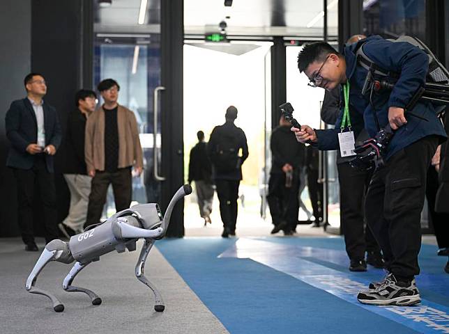 A visitor interacts with a smart robotic dog at the Light of Internet Expo in Wuzhen, east China's Zhejiang Province, Nov. 19, 2024. The Light of Internet Expo kicked off on Tuesday during the 2024 World Internet Conference (WIC) Wuzhen Summit in the water-town of Wuzhen, showcasing the latest technological achievements, especially those made in the artificial intelligence (AI) area. (Xinhua/Cai Xiangxin)