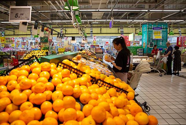 File photo shows a consumer selects fruits at a supermarket in Xinghua City, east China's Jiangsu Province. (Photo by Zhou Shegen/Xinhua)