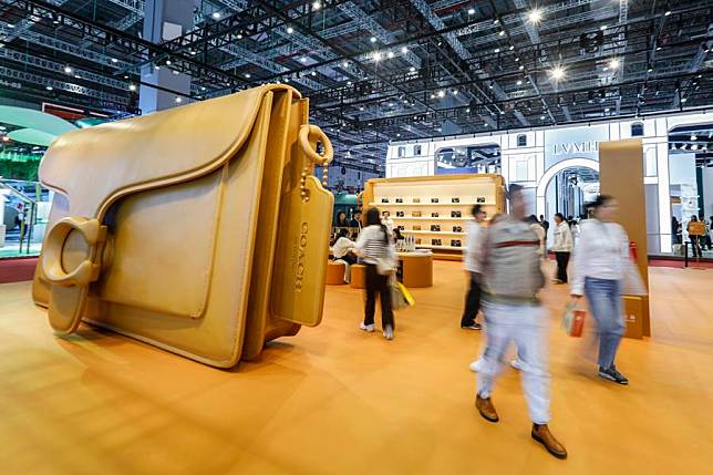 People visit the booth of Coach at the Consumer Goods Exhibition Area during the seventh China International Import Expo (CIIE) in east China's Shanghai, Nov. 7, 2024. (Photo by Chang Nengjia/Xinhua)