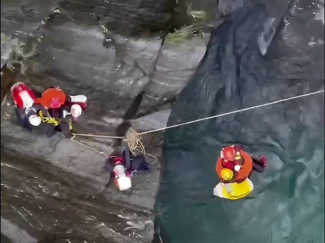 飛龍瀑布溯溪團，五位山友吊掛在山壁上一整夜，空勤直昇機一一吊掛救起。（記者鄭錦晴翻攝）