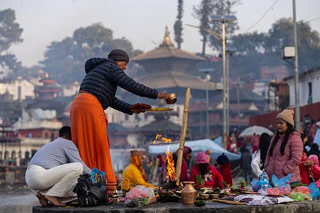 A priest helps a devotee to make offerings to the departed soul during the Bala Chaturdashi festival on the premises of Pashupatinath Temple in Kathmandu, Nepal, Nov. 30, 2024. (Hari Maharjan/Xinhua)