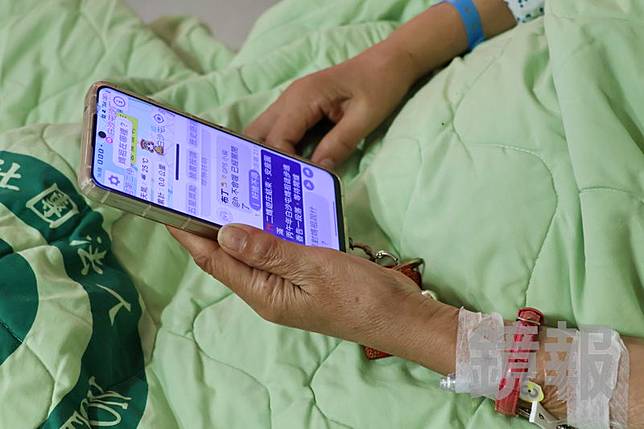 婦人住院還滑著手機，關切白沙屯媽祖最新動態。大甲李綜合醫院提供