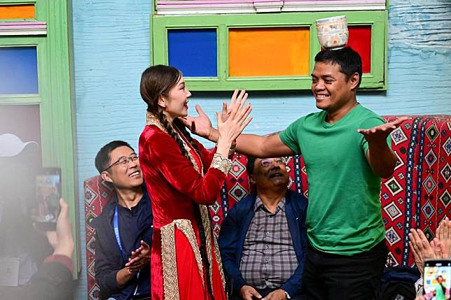 An attendee of the 6th World Media Summit learns local dancing at &ldquo;Guli's Home&rdquo;, a local resident's yard converted into a tourist resting place, in Kashgar, northwest China's Xinjiang Uygur Autonomous Region, Oct. 16, 2024. (Xinhua/Ding Lei)