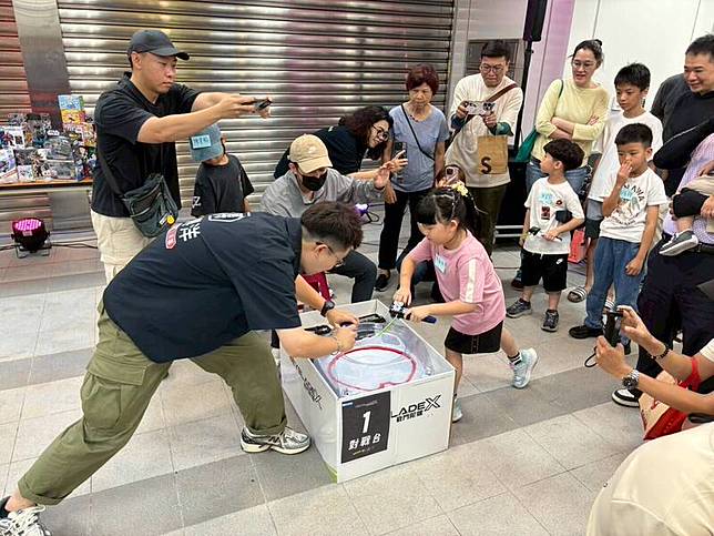 張博洋(左)在戰鬥陀螺大賽中，被幼稚園小妹妹(右)擊潰。(記者葛祐豪翻攝)
