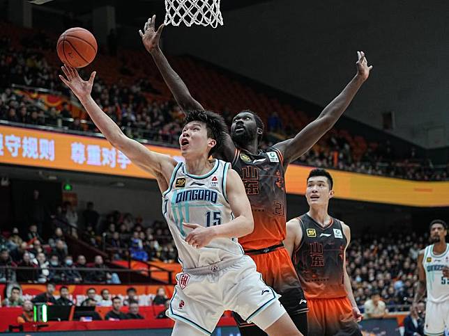 Yang Hansen (L) of Qingdao Eagles goes for a basket against Christ Koumadje of Shandong Heroes during a match between Shandong Heroes and Qingdao Eagles at the 2024-2025 season of the Chinese Basketball Association (CBA) league in Jinan, east China's Shandong Province, Dec. 23, 2024. (Xinhua/Zhu Zheng)