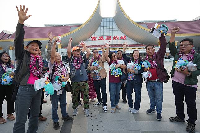 Tourists from a tour group, the first one from the Association of Southeast Asian Nations (ASEAN) member states since China introduced its new visa relaxation policy, pose for photos in front of the Xishuangbanna railway station in Jinghong City, Xishuangbanna Dai Autonomous Prefecture, southwest China's Yunnan Province, Feb. 18, 2025. (Xinhua/Chen Xinbo)