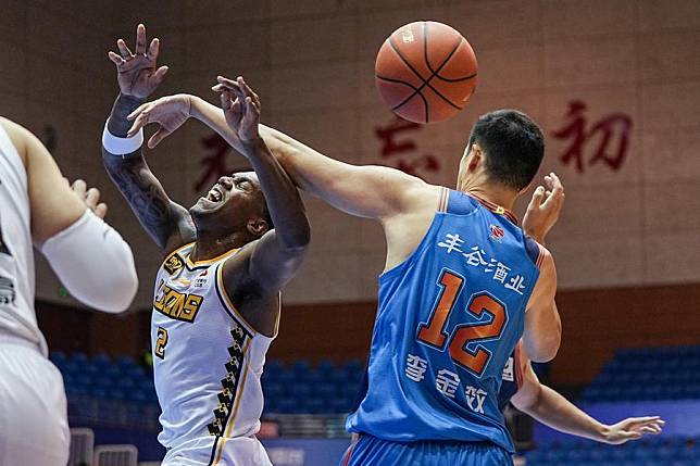 Nathan Knight (L) of Zhejiang Lions vies for the ball with Li Jinxiao of Sichuan Blue Whales during a Chinese Basketball Association (CBA) Club Cup match in Yantai, east China's Shandong Province, Nov. 13, 2024. (Xinhua/Zhu Zheng)