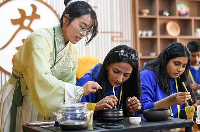 Students learn tea art under the instruction of a student (L) from Xinjiang Normal University during the 2024 &ldquo;Chinese Bridge&rdquo; Spring Camp for students from SCO countries, in northwest China's Xinjiang Uygur Autonomous Region, April 15, 2024. (Xinhua/Wang Fei)