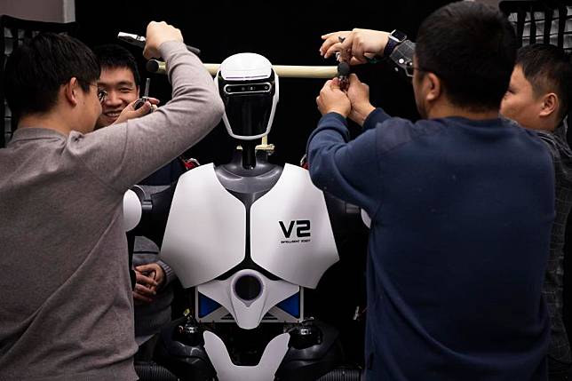 Researchers adjust a humanoid robot at an AI laboratory on Jan. 31, 2024. (Xinhua/Jin Liwang)