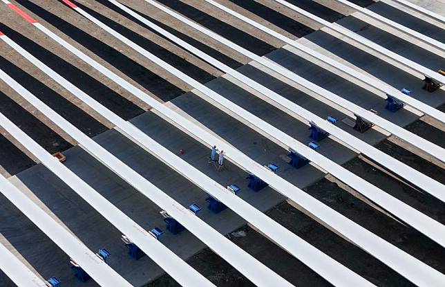 An aerial drone photo taken on Sept. 10, 2024 shows workers checking wind turbine blades at an industrial park in Kazak Autonomous County of Barkol, northwest China's Xinjiang Uygur Autonomous Region. (Xinhua/Hu Huhu)