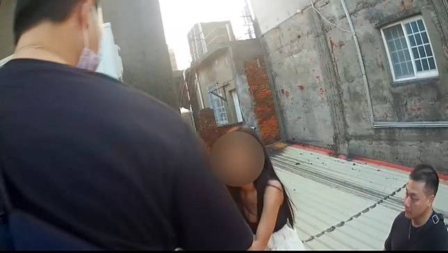 女子為躲避警方查緝，驚慌逃至5樓頂樓，踩著鐵皮屋頂藏身柱子後方。圖：讀者提供