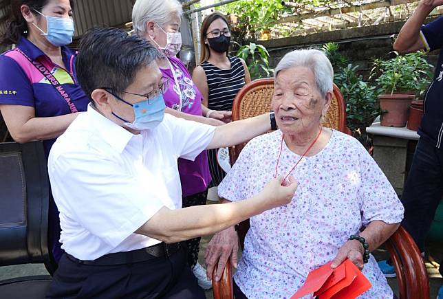 竹縣長楊文科為百歲婆張徐賢妹戴上金鎖片，讓老人家好暖心。（記者彭新茹攝）