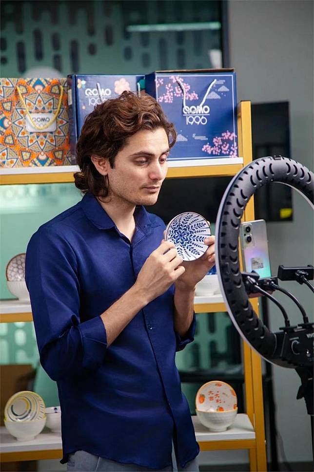 Hassan Ahmad, a 25-year-old Pakistani, displays a ceramic product via livestreaming in Jingdezhen, east China's Jiangxi Province, March 16, 2024. (Xinhua)