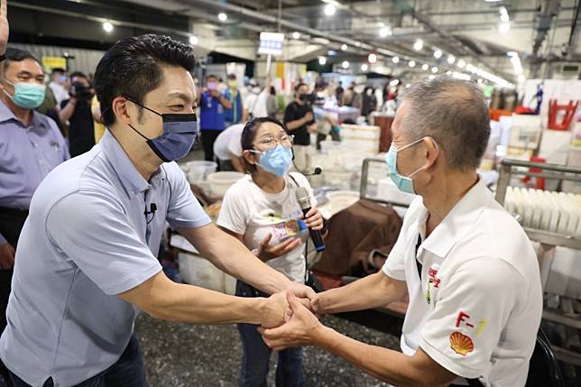蔣萬安在黨籍議員陪同下至萬華中央魚市場拜會，向攤商承諾當選會加速改建、整頓環境衛生。 （蔣萬安競辦提供）