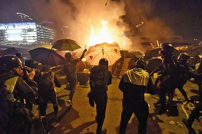 Hard-core protesters launch petrol bombs outside the Hong Kong Polytechnic University during unrest that police labelled a riot. Photo: Kyodo