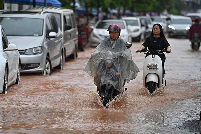 Citizens ride on a flooded street in Nanning, south China's Guangxi Zhuang Autonomous Region, May 8, 2024. (Xinhua/Zhou Hua)