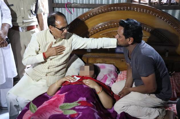印度中央邦首席部長希夫拉傑·辛格·喬漢探望因為拒絕性騷擾而臉部遭劃傷，縫了118針的受傷女子。   圖 : 翻攝自觀察者網