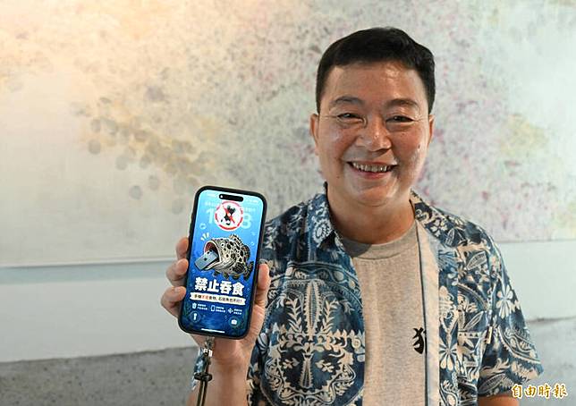 手機主人陳志東特地把新的手機桌面換成龍膽石斑吃下手機的桌面圖案。(記者李惠洲攝)