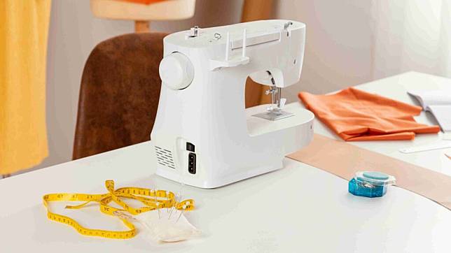 縫紉機推薦＿一台白色的縫紉機放在桌子上 旁邊還有針和量尺