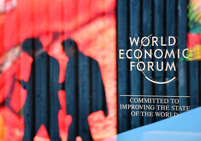 People walk past the logo of the World Economic Forum (WEF) in Davos, Switzerland, on Jan. 14, 2024. (Xinhua/Lian Yi)