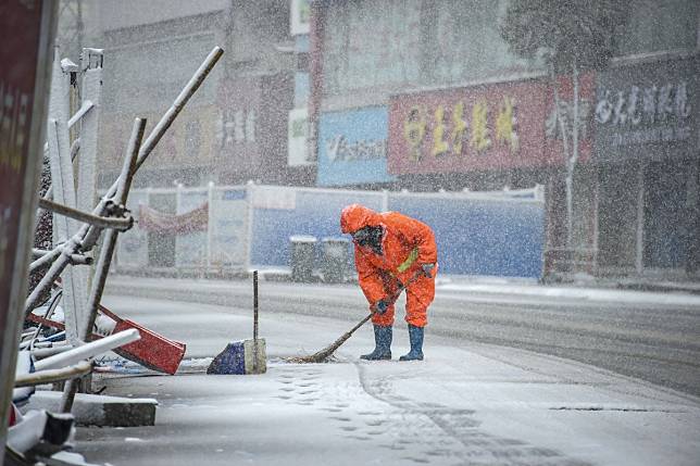 A sanitation worker cleans the street during snowfall in Xiaogan, Hubei province, last week. Thousands of Hongkongers are stuck in the province, where the coronavirus outbreak began. Photo: Xinhua