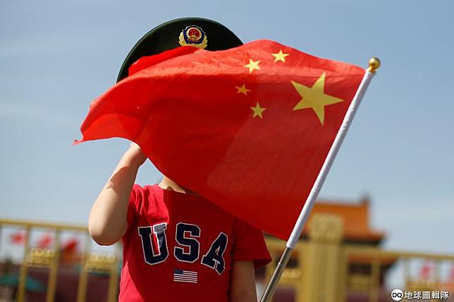 在北京街頭，一名孩子身穿寫有「美國」字樣的上衣，一邊揮舞著中國國旗。 路透社/達志影像