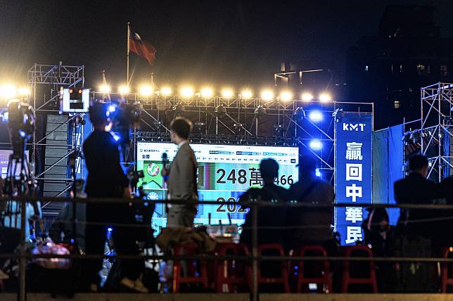 1月13日傍晚，國民黨在板橋第一體育場外廣場舉辦開票之夜，現場觀眾與媒體關注螢幕上顯示的開票數字。（攝影／陳曉威）  
