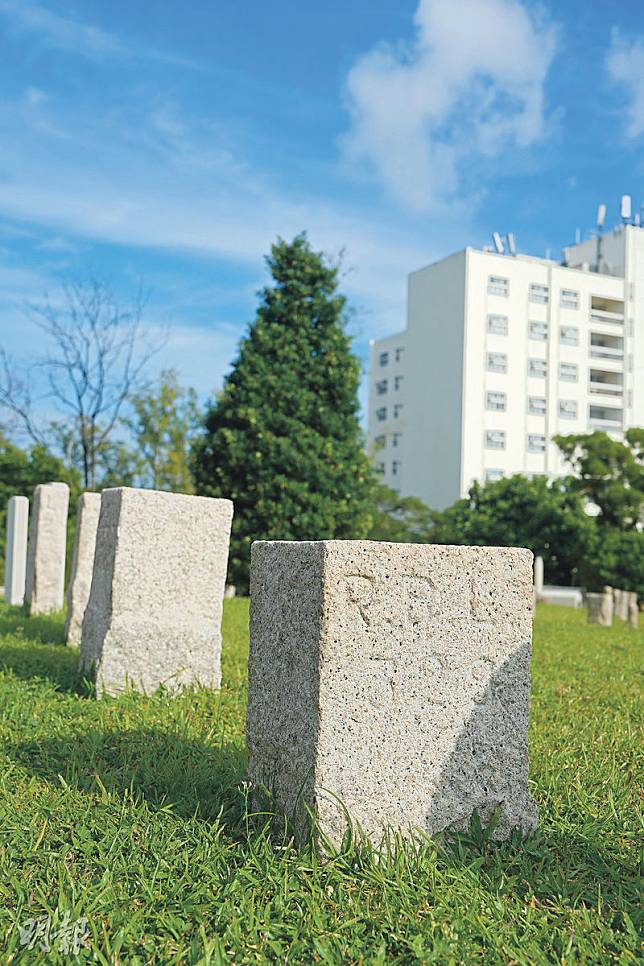 赤柱軍人墳場豎立的墓碑材質、形狀不一，在十字架後的草地上，有一大片草地豎立以地段界石為石材的墓碑，背面、側面可見刻上的界石類型和地段號碼。（黃志東攝）