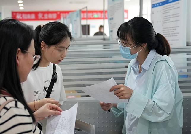 A recruiting representative &reg; talks with job seekers at a job fair dedicated to the modern service sector in Hangzhou, east China's Zhejiang Province, June 5, 2024. (Xinhua/Han Chuanhao)