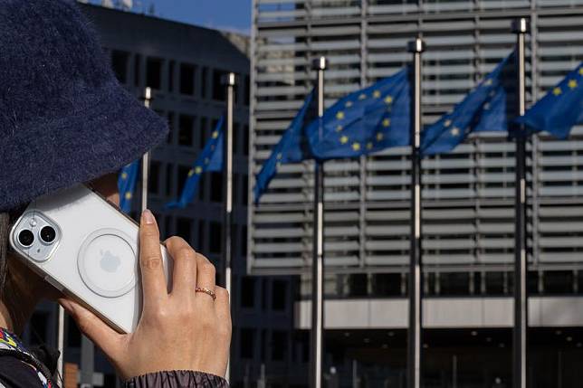 A woman talks through an iPhone at the Berlaymont building, headquarters of the European Commission, in Brussels, Belgium, on March 4, 2024. (Xinhua/Meng Dingbo)