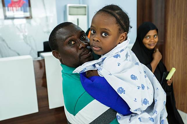 A young Tanzanian father holds his daughter before her heart surgery at Jakaya Kikwete Cardiac Institute in Dar es Salaam, Tanzania, on Jan. 18, 2025. (Xinhua/Emmanuel Herman)