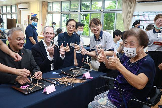 美國衛生福利部代表團體驗藺草編織，日照中心八十三歲王陳奶奶(右)也說讚。