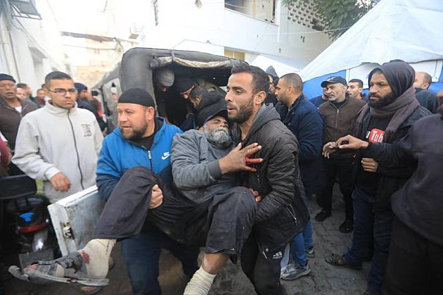 People transfer a man injured in an Israeli bombing at Al-Ahli Arab Hospital in Gaza City, on Jan. 2, 2025. (Photo by Mahmoud Zaki/Xinhua)