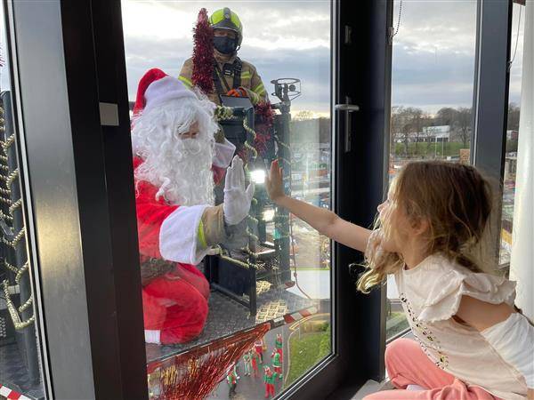 聖誕老公公坐著消防雲梯車，隔著玻璃窗與孩子們會面。（圖片來源／The Archie Foundation臉書）