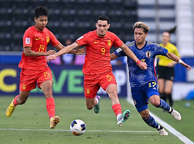 China's Behram Abduweli © goes for the ball against Japanese player Kuryu Matsuki ® during their U23 Asian Cup group match in Doha, Qatar on April 16, 2024. (Xinhua/Ni Ku)