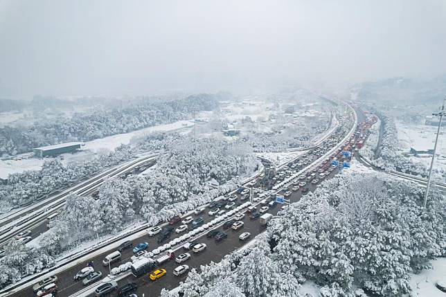 An aerial drone photo shows vehicles running on the road during snowy weather in Changsha, central China's Hunan Province, Jan. 22, 2024. (Xinhua/Chen Sihan)