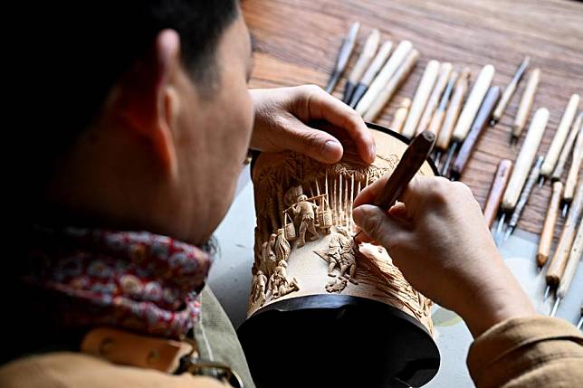 Hong Jianhua works on a bamboo carving at Huizhou Sculpture Museum in Huizhou District of Huangshan City, east China's Anhui Province, Jan. 7, 2025. (Xinhua/Huang Bohan)