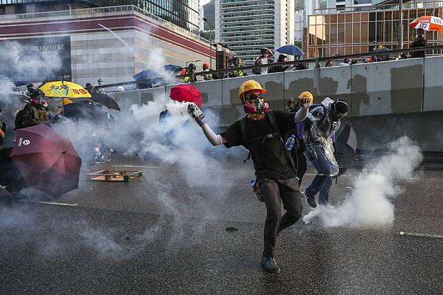 Protesters hurl petrol bombs and other objects at the Central Government Offices in Tamar as they hold another rally and march in Hong Kong. Photo: Sam Tsang