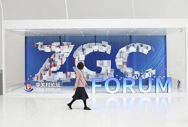 A woman walks past an art installation at the Zhongguancun International Innovation Center, venue for the 2024 Zhongguancun Forum (ZGC Forum) Annual Conference, in Beijing, capital of China, April 25, 2024. (Xinhua/Ren Chao)