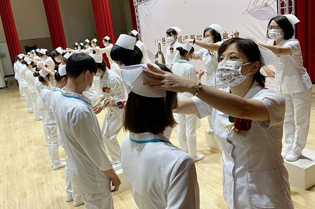弘光科大護理學院舉辦加冠典禮，由老師為女學生加冠、男學生別胸花。（記者陳金龍攝）
