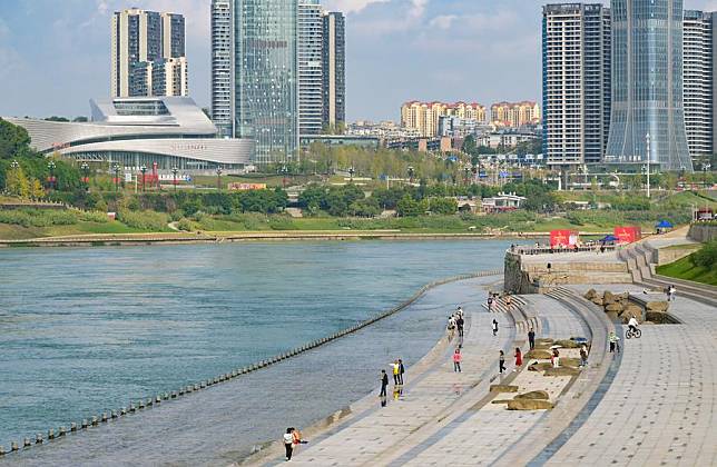 People walk on a bank road of the Sanjiangkou Yangtze River Park in Yibin City, southwest China's Sichuan Province, Oct. 13, 2024. (Xinhua/Li He)