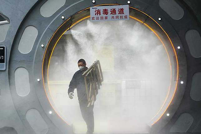 A man walks through a disinfection gate before leaving the work area of Chongqing Mexin Group in southwest China's Chongqing municipality on February 12. Photo: Xinhua