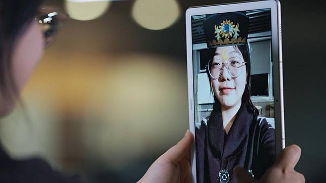 This undated file photo shows a woman trying the mobile phone application “AR Luzhou Intangible Cultural Heritage.”