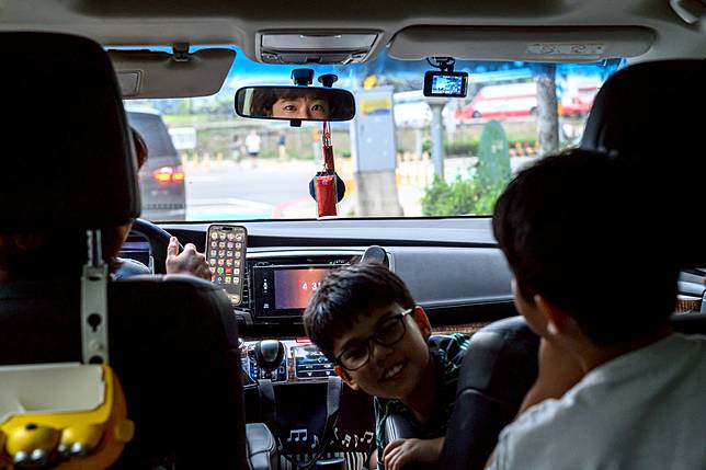 在接送車程中，手機、工作與親職任務往往交織在一起，「時間貧窮」成為育兒家長共同的感受。（攝影／黃世澤）