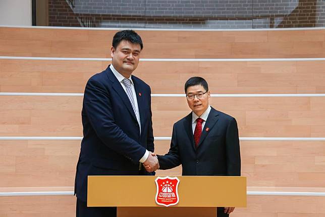 Chinese Basketball Association (CBA) president Guo Zhenming &reg; shakes hands with his predecessor Yao Ming. (Handout via Xinhua)