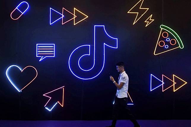 A man holding a phone walks past a sign of Chinese company ByteDance's app TikTok, known locally as Douyin, in Hangzhou, China. Photo: Reuters