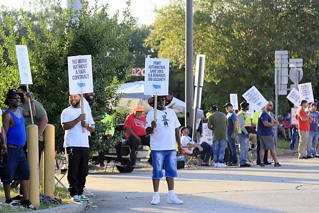 Striking port workers holding signs stand at the entrance to the Port of New Orleans, Louisiana, the United States, on Oct. 2, 2024. (Photo by Lan Wei/Xinhua)